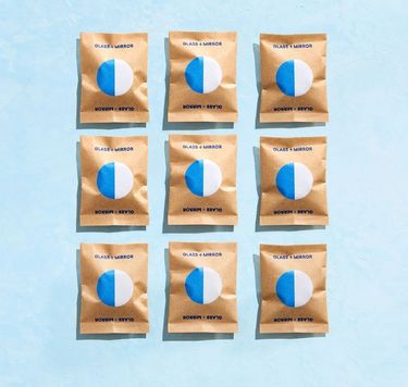 9 Blueland Glass + Mirror refill tablets in compostable wrappers against blue background
