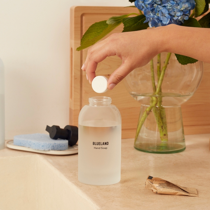 Dropping a tablet in a Blueland Refillable Hand Soap Bottle