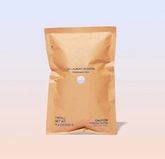 1 pouch of Oxi Laundry Booster powder in compostable packaging against peach background