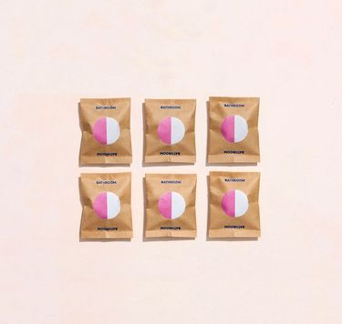 6 Blueland Bathroom refill tablets in compostable wrappers against pink background