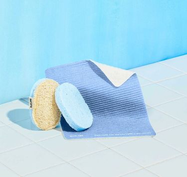 Cleaning Companions Pack: 1 Periwinkle Cloud Cloth, 1 Scrub Sponge, 1 blue Pop-Up Sponge on white tile against blue background