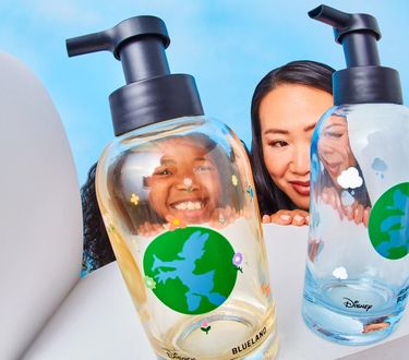 Mother and daughter look up behind Donald & Daisy hand soap duo bottles