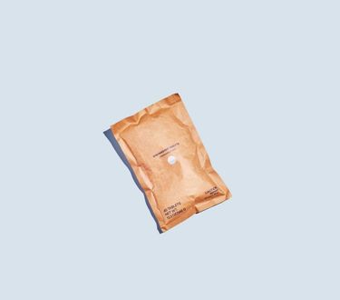 Compostable pouch of dishwasher tablets against blue background