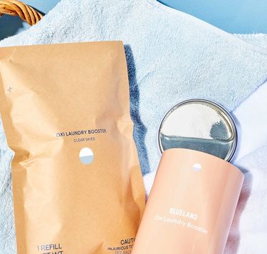 Oxi Laundry Booster Starter Set: 1 Forever Tin and 1 compostable pouch of powder in laundry basket