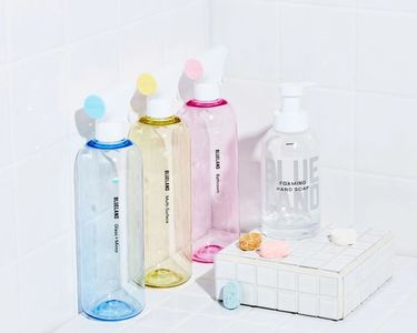 Clean Essentials Kit on white tile: 3 refillable cleaning bottles and wrapped tablets, 1 Hand Soap bottle and wrapped tablet
