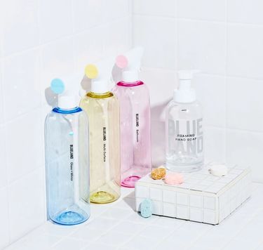 Clean Essentials Kit on white tile: 3 refillable cleaning bottles and wrapped tablets, 1 Hand Soap bottle and wrapped tablet
