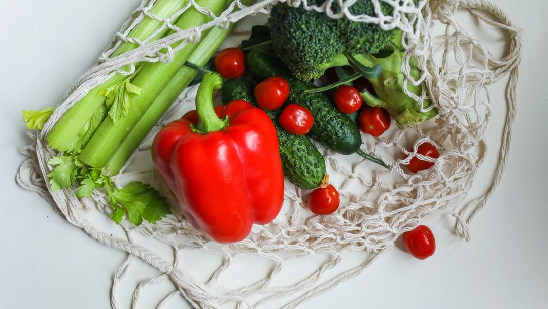 Vegetables in string produce bag on white counter