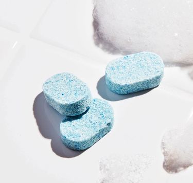 3 Blueland Glass + Mirror refill tablets against a white tile and some foam