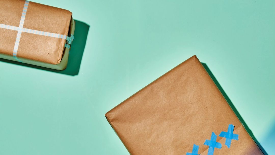 Teal background, two brown paper packaged with colorful washi-tape