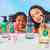 Young girl and mother posed behind Disney & Blueland hand soap bottles on surface with hand soap refills on table