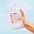 Hand holds Foaming Hand Soap bottle in air with tablet dissolving with blue background