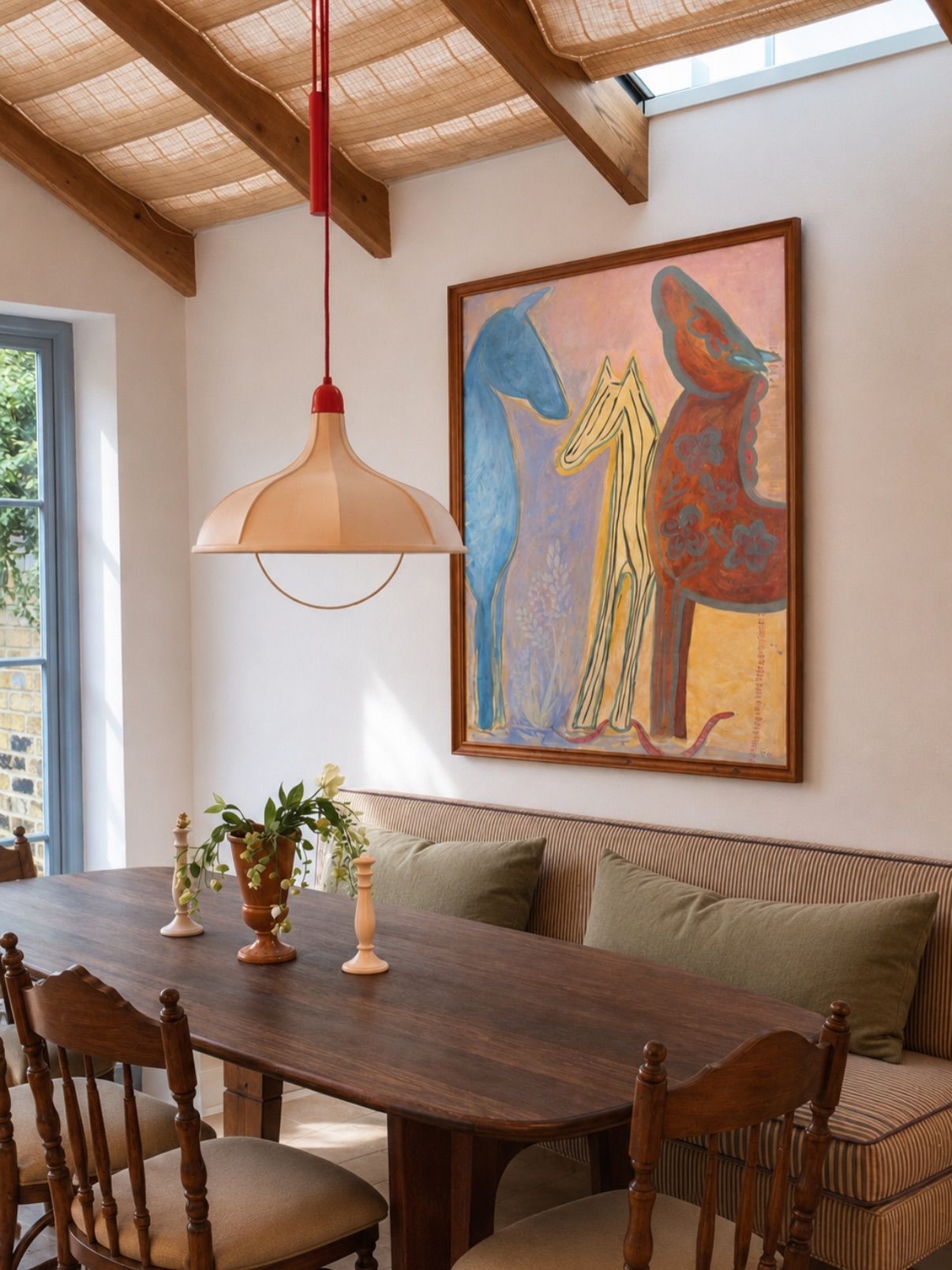 Three Graces hung in a dining nook with a wood-beamed ceiling
