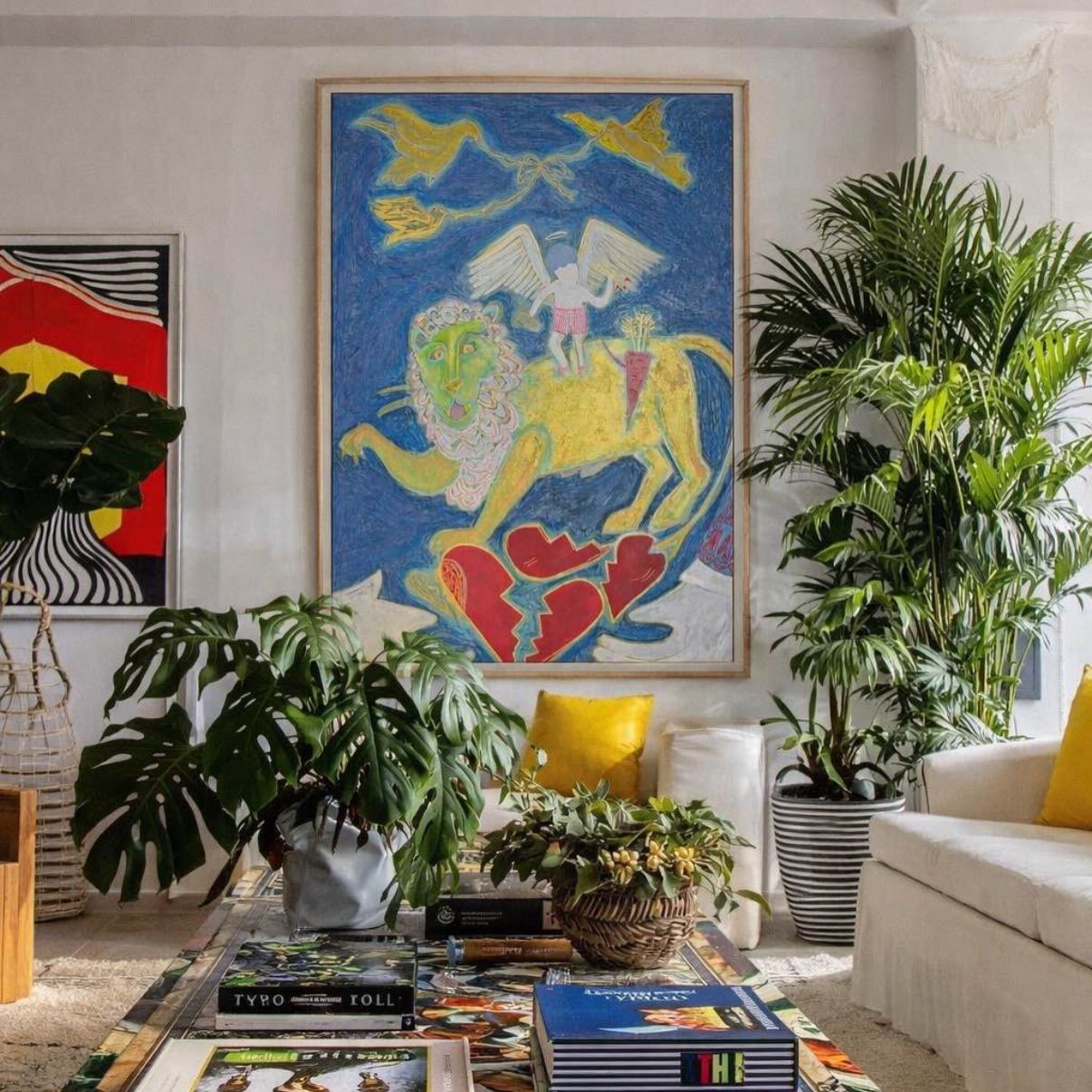 Love Also Rises hung in a plant-filled living room