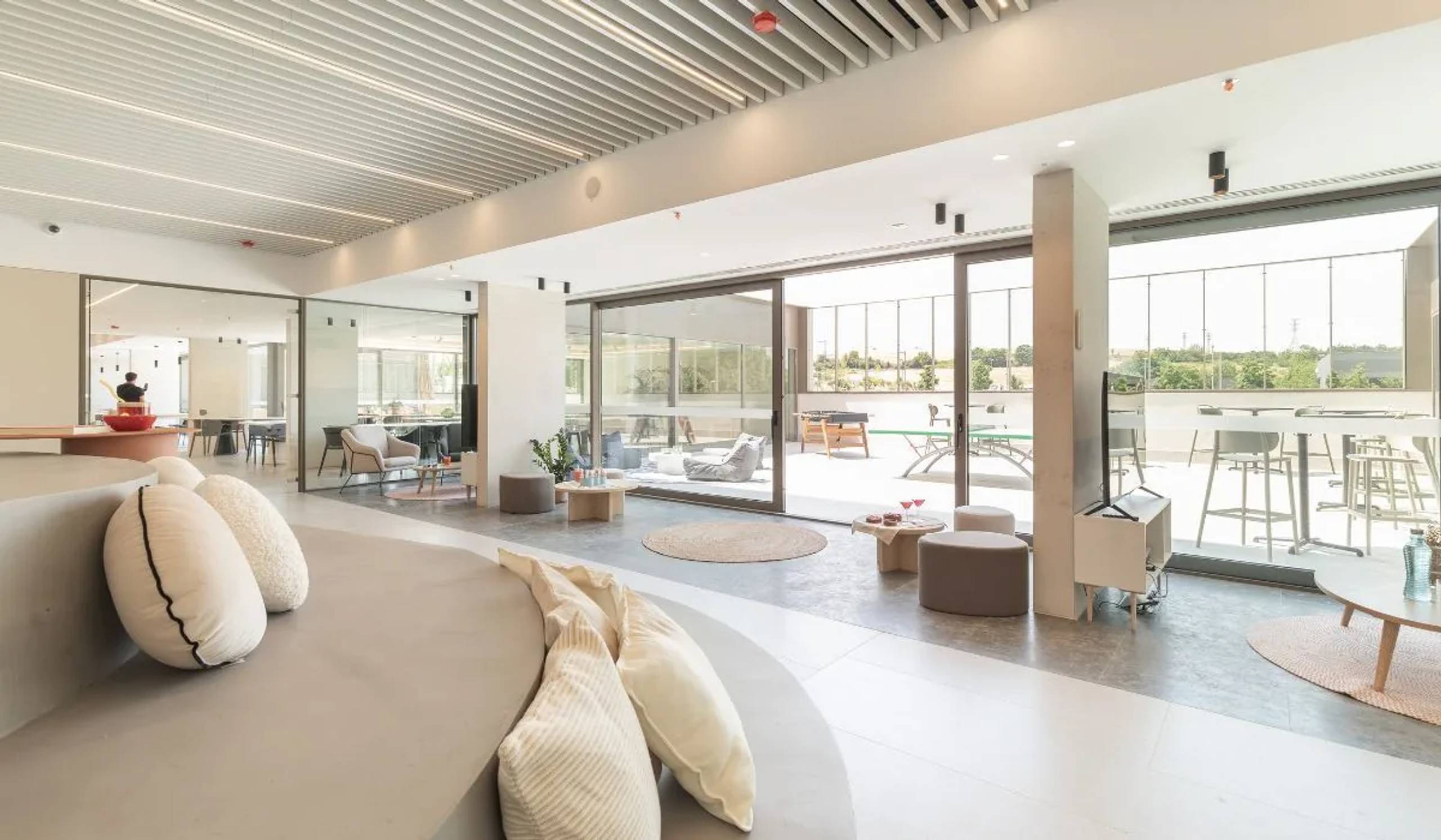 Sala común con ventanales al exterior y techo de listones de madera