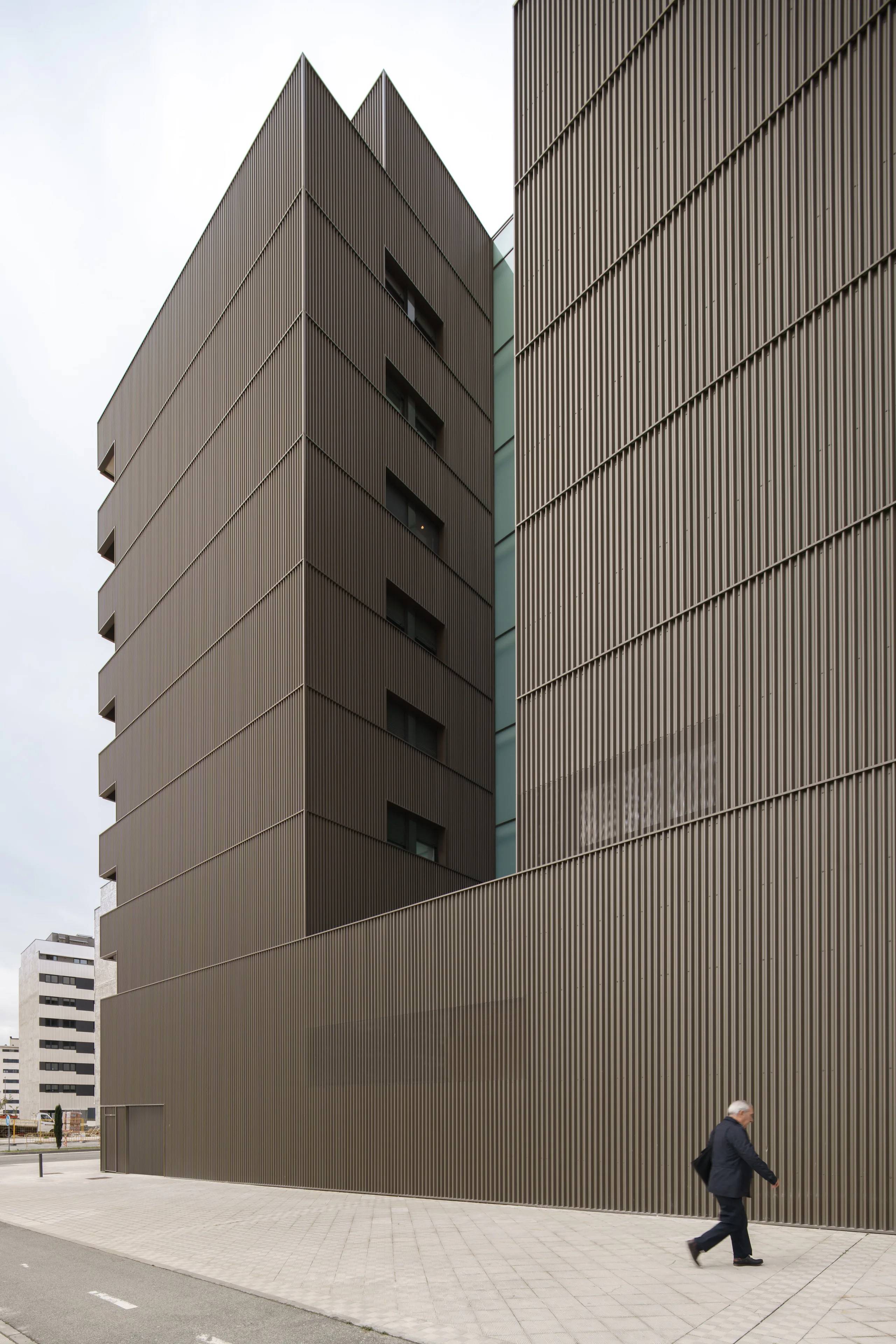 Encuentro de dos fachadas: chapa vertical y ventanas retranqueadas