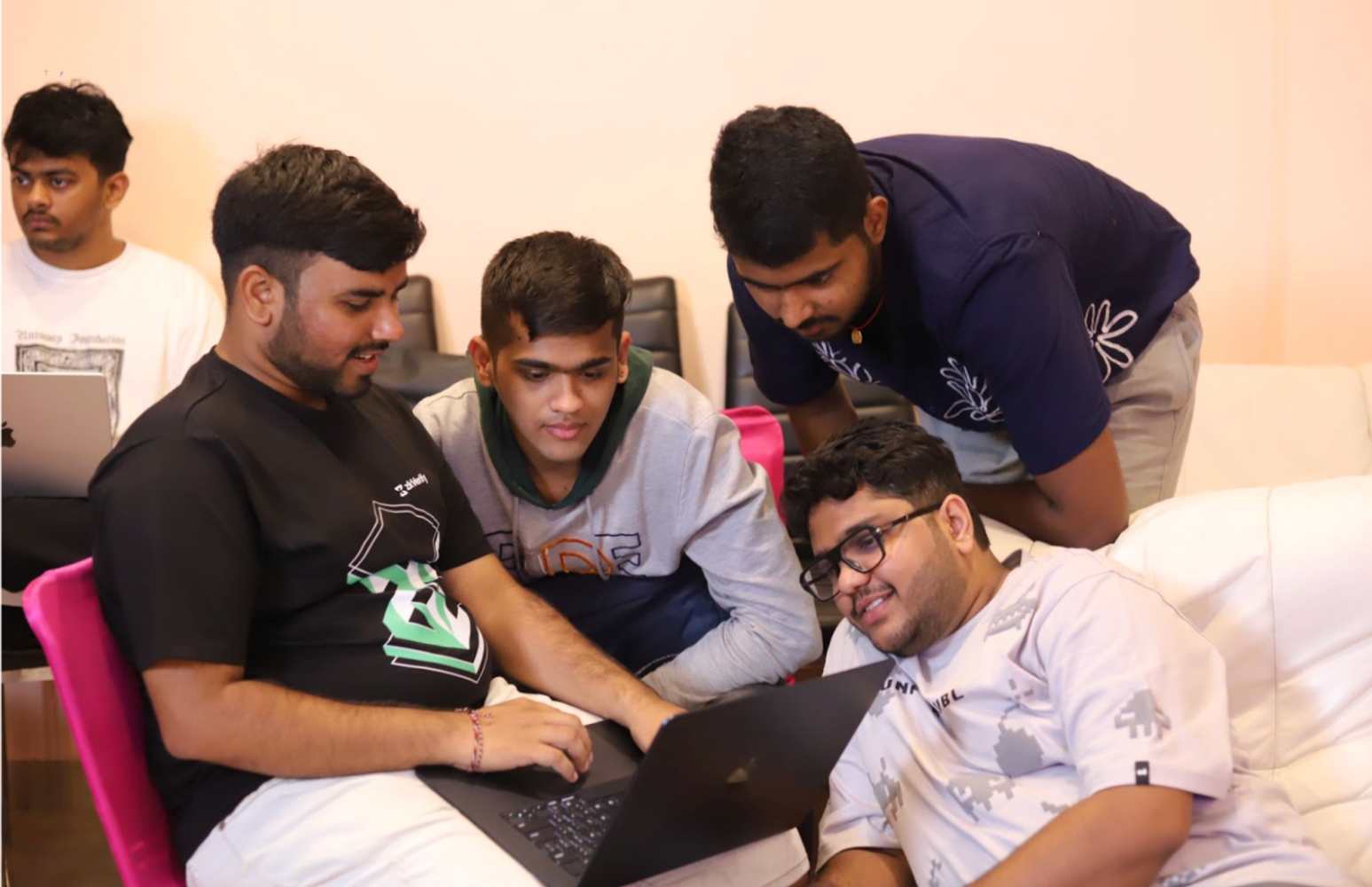 Young men collaborating around a laptop.