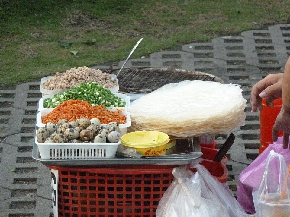 Rice paper, quail eggs and fresh toppings at a bánh tráng nướng stall in Saigon