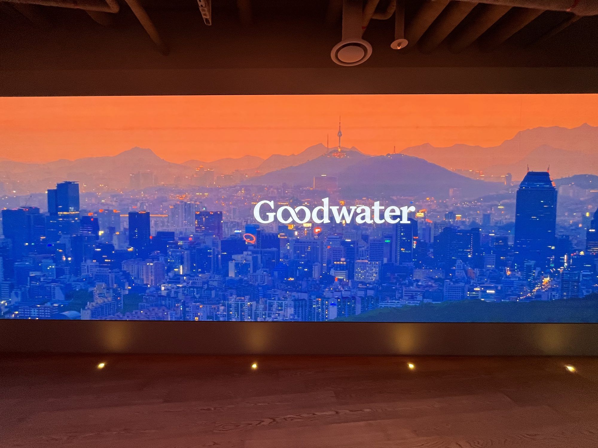 ソウルのスカイラインの上に掲げられたGoodwater Capitalのロゴ