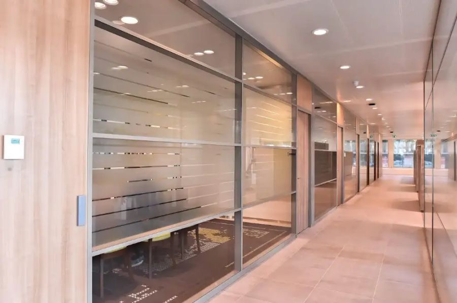 Gesloten systeemwand met glas en dichte deur in een modern kantoorpand — Rabobank, Spijker BV