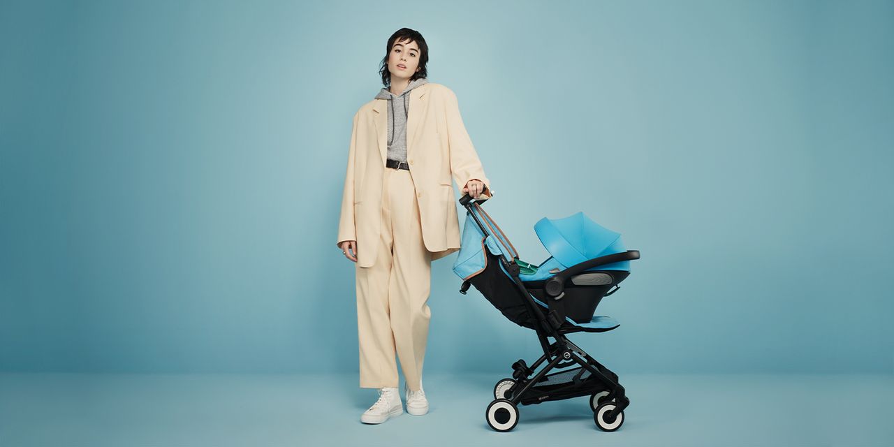 Kvinna med Cybex resevagn och har babyskyddet fastklickat på resevagnen, så smidigt!