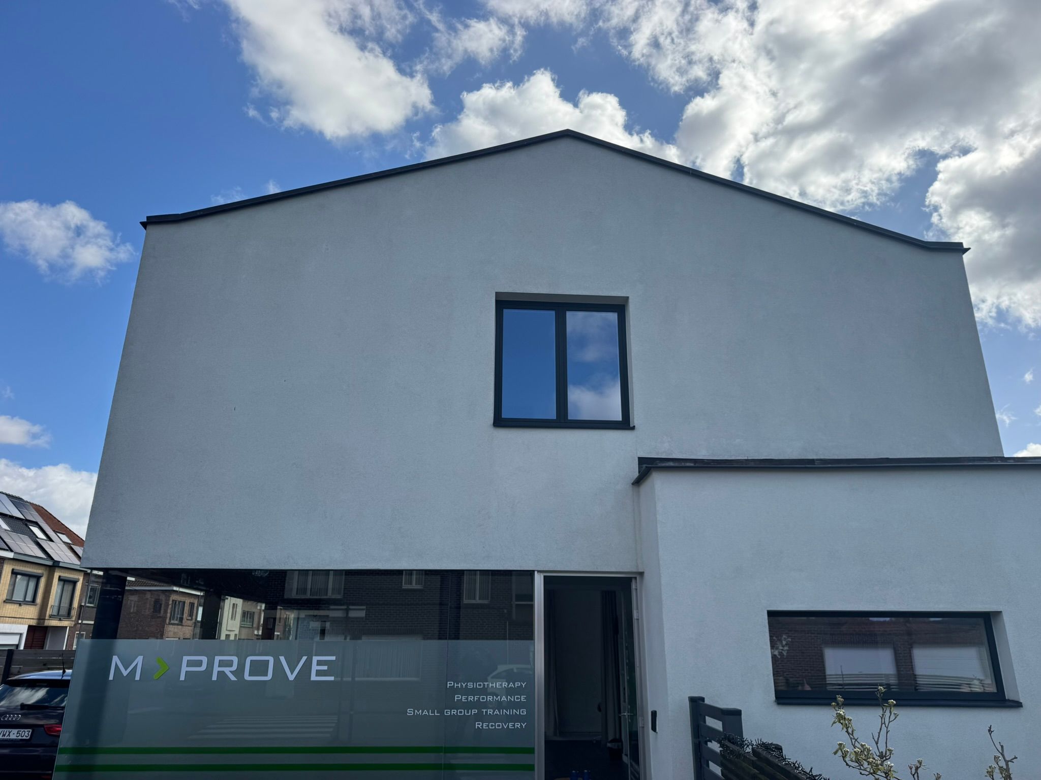 Gereinigde witte crepi-gevel in Drongen na zachte reiniging, egaal en fris resultaat