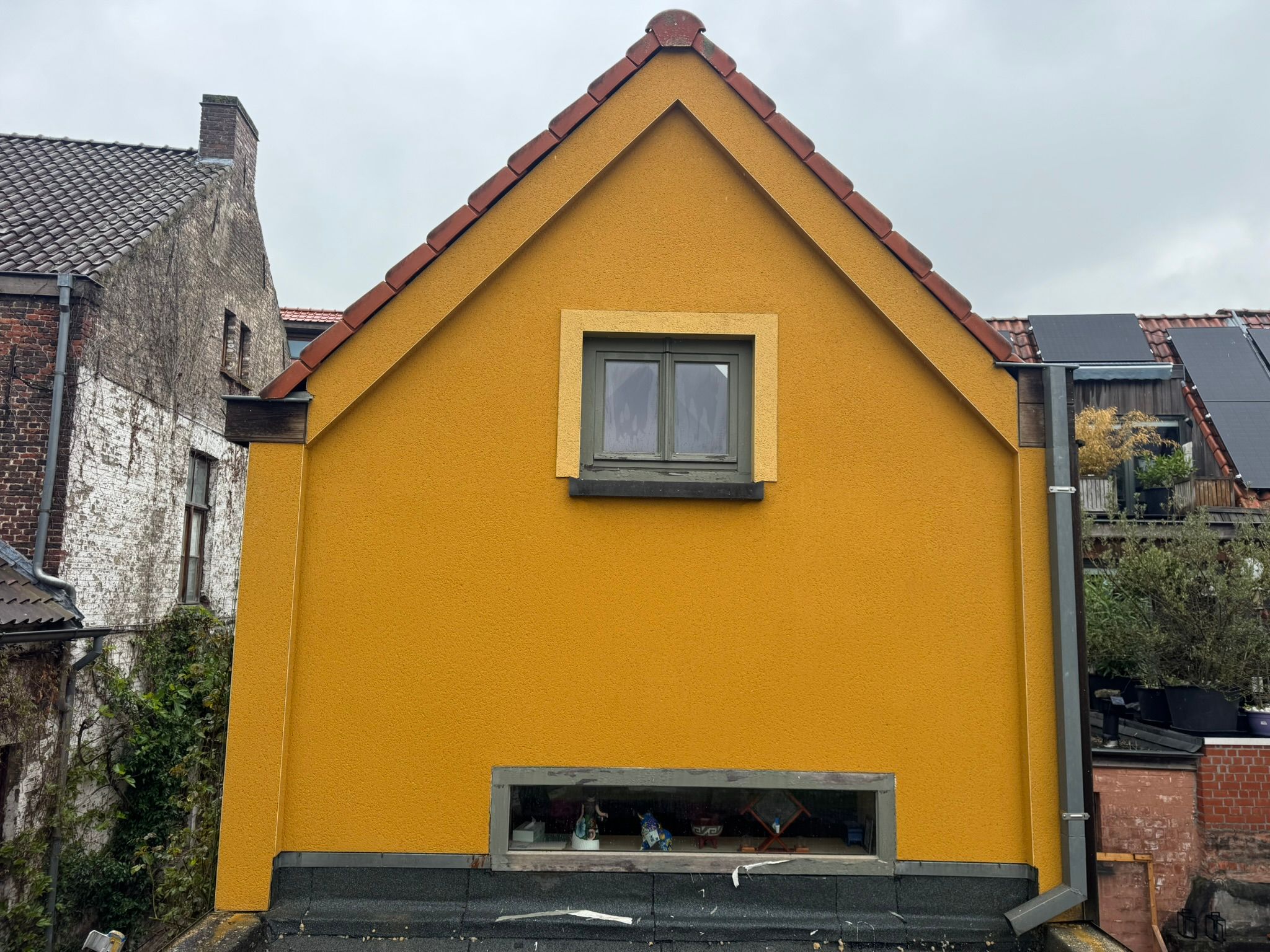 Gele crepi gevel volledig schoon en egaal — Varkensstraat Gent, na de reiniging