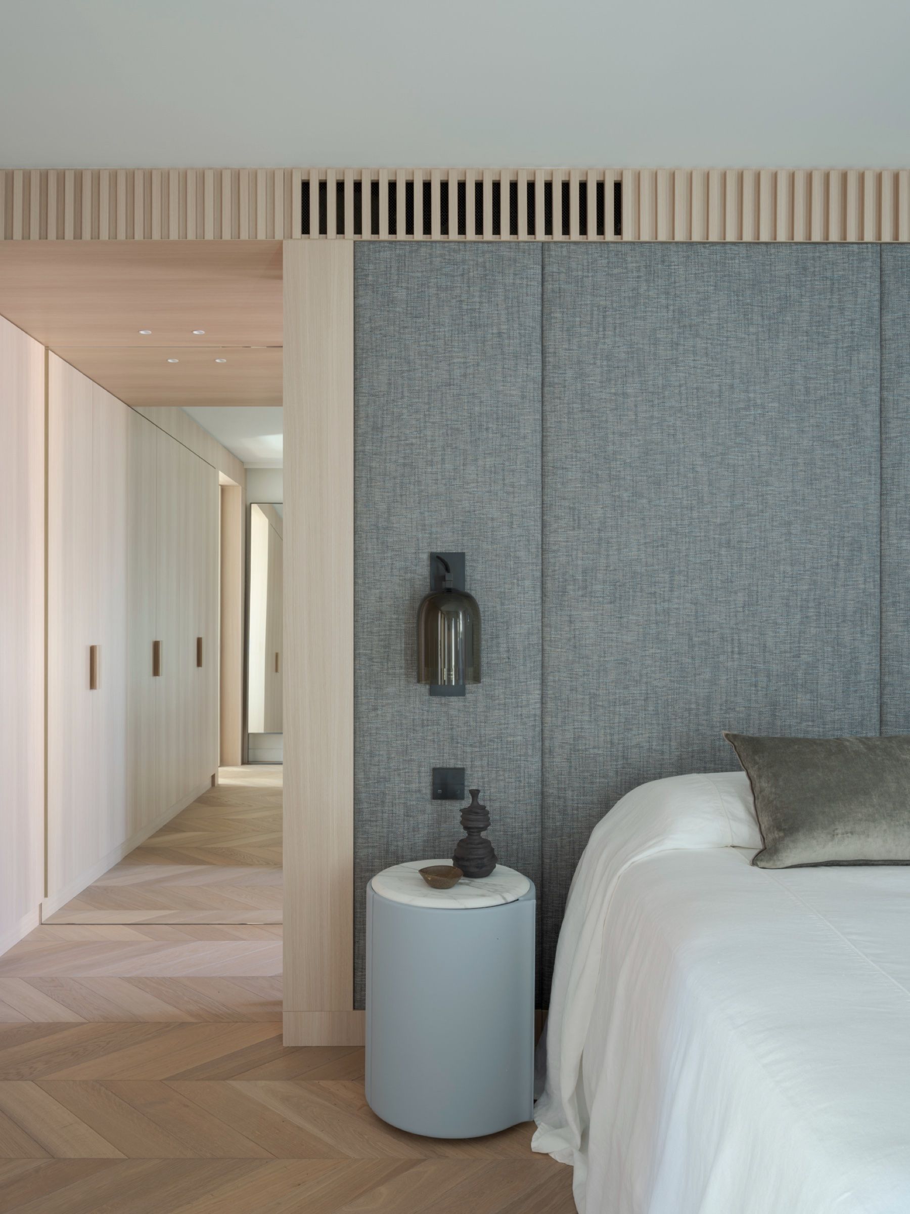 The master bedroom in woven grey panelling, corridor beyond