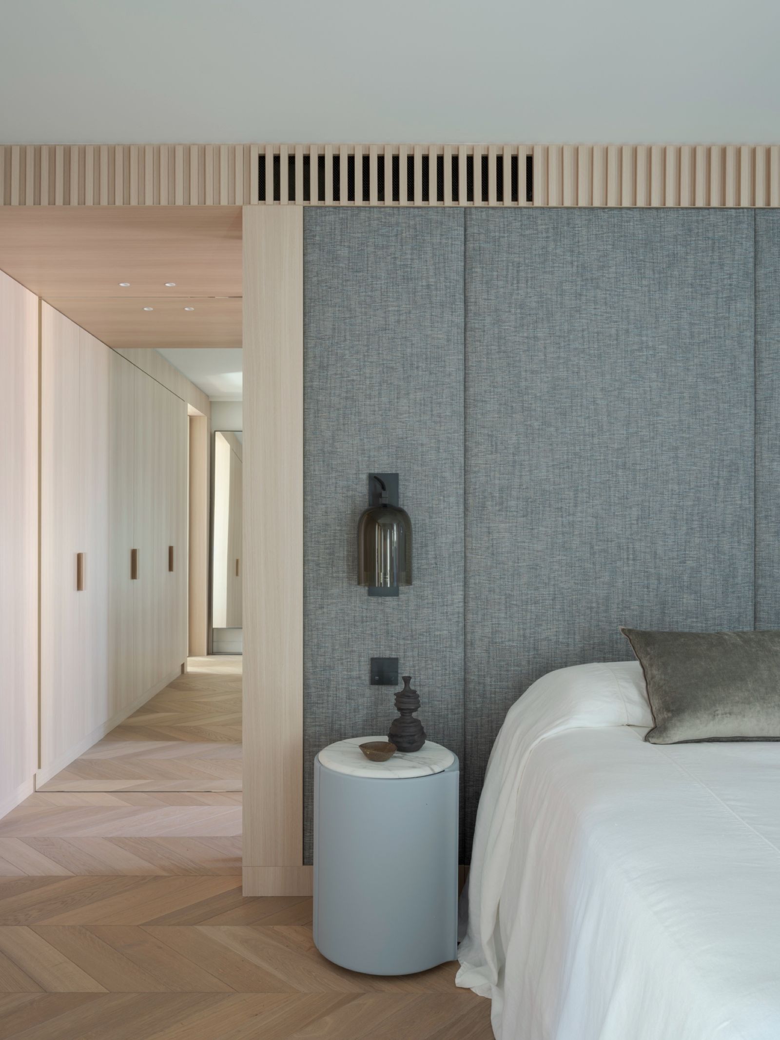 The master bedroom in woven grey panelling, corridor beyond