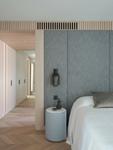 The master bedroom in woven grey panelling, corridor beyond