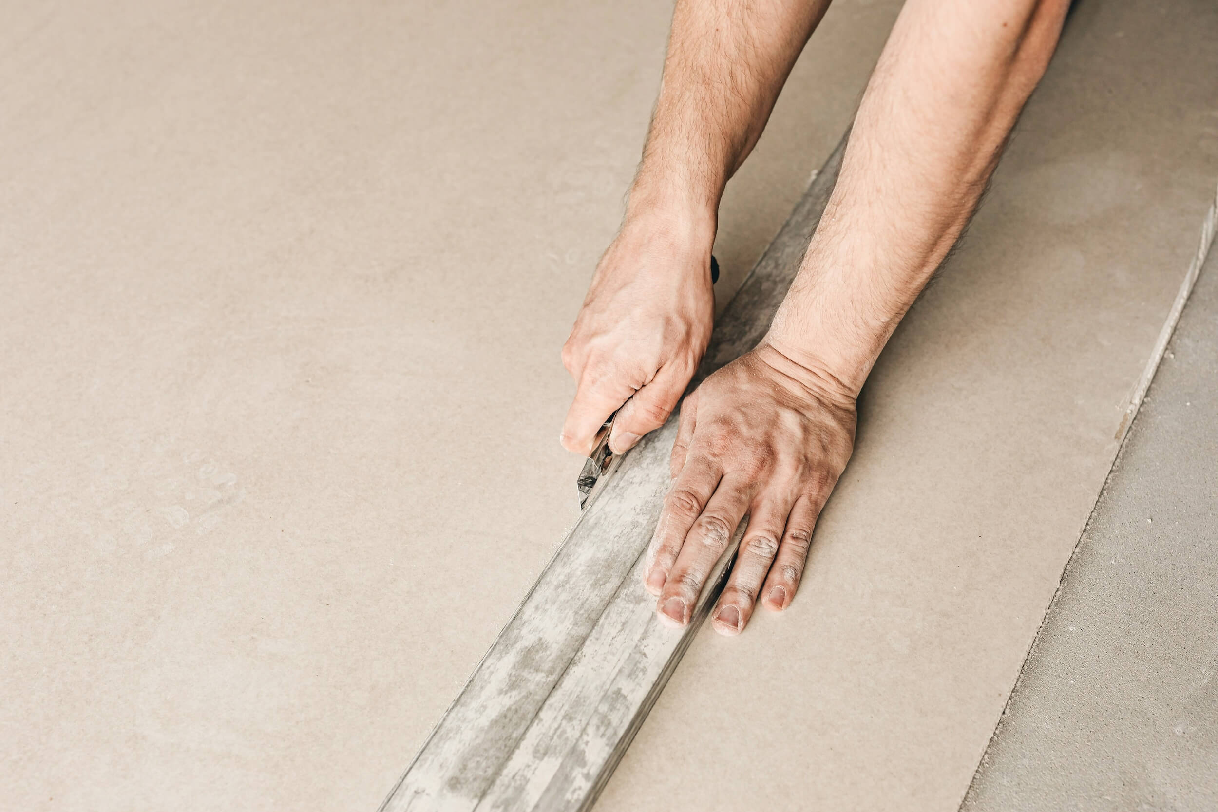 Hands screeding a rendered wall