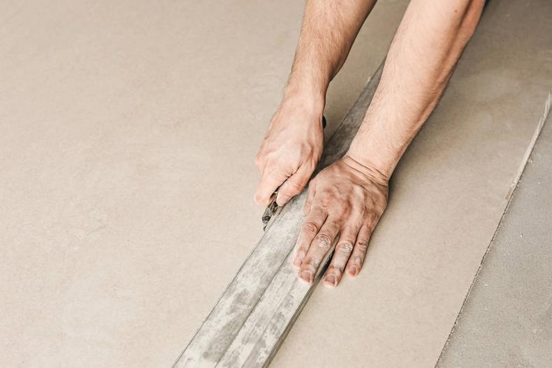 Hands screeding a rendered wall