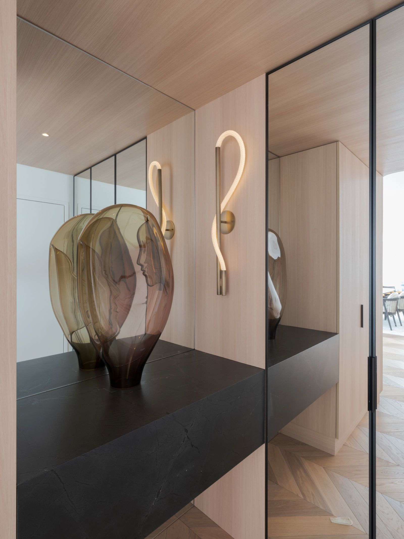 A glass sculpture against the mirrored entry joinery