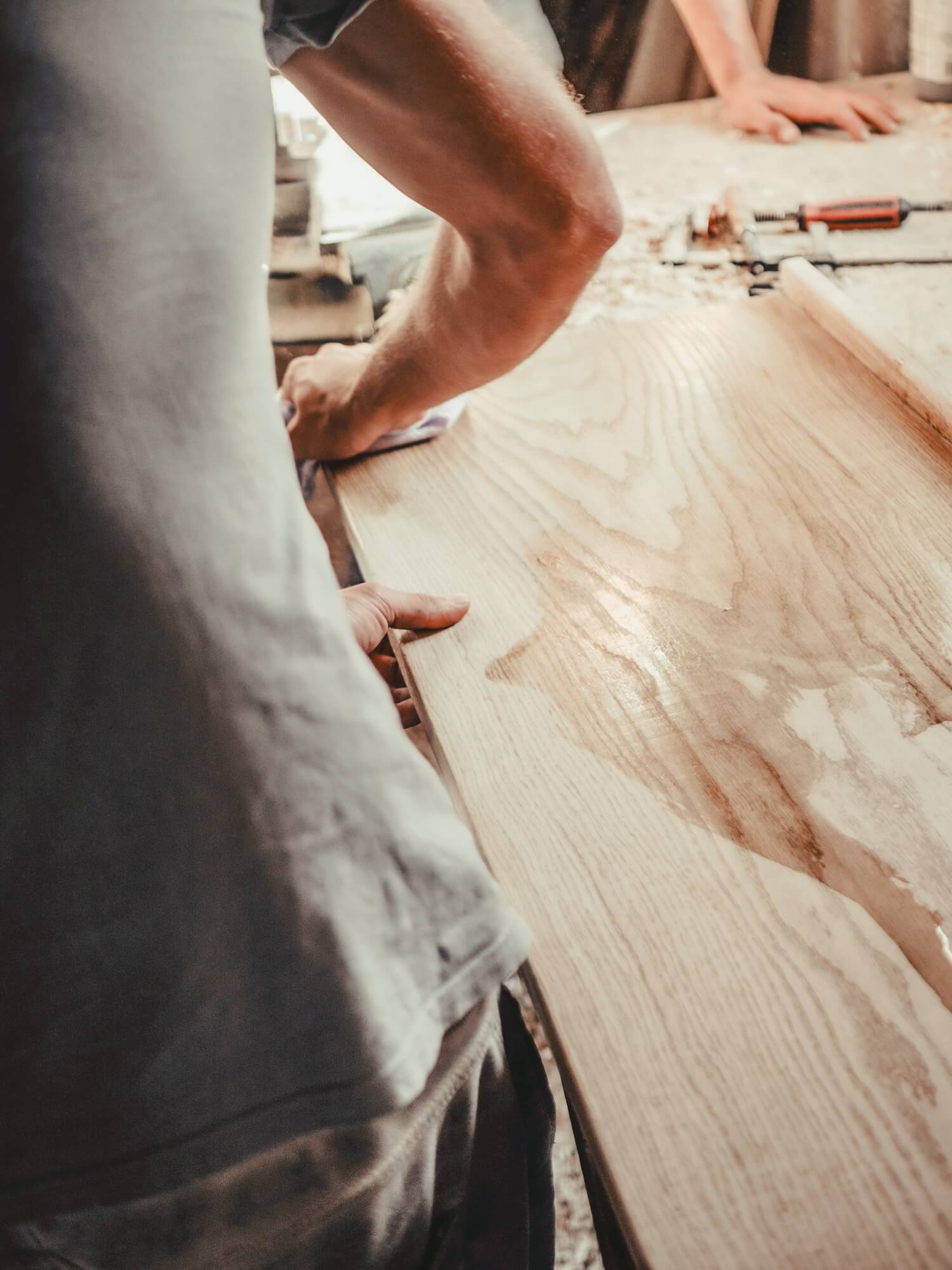 Hands shaping a timber board