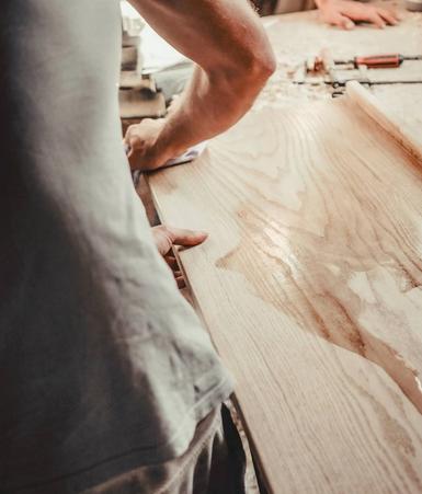 Hands shaping a timber board