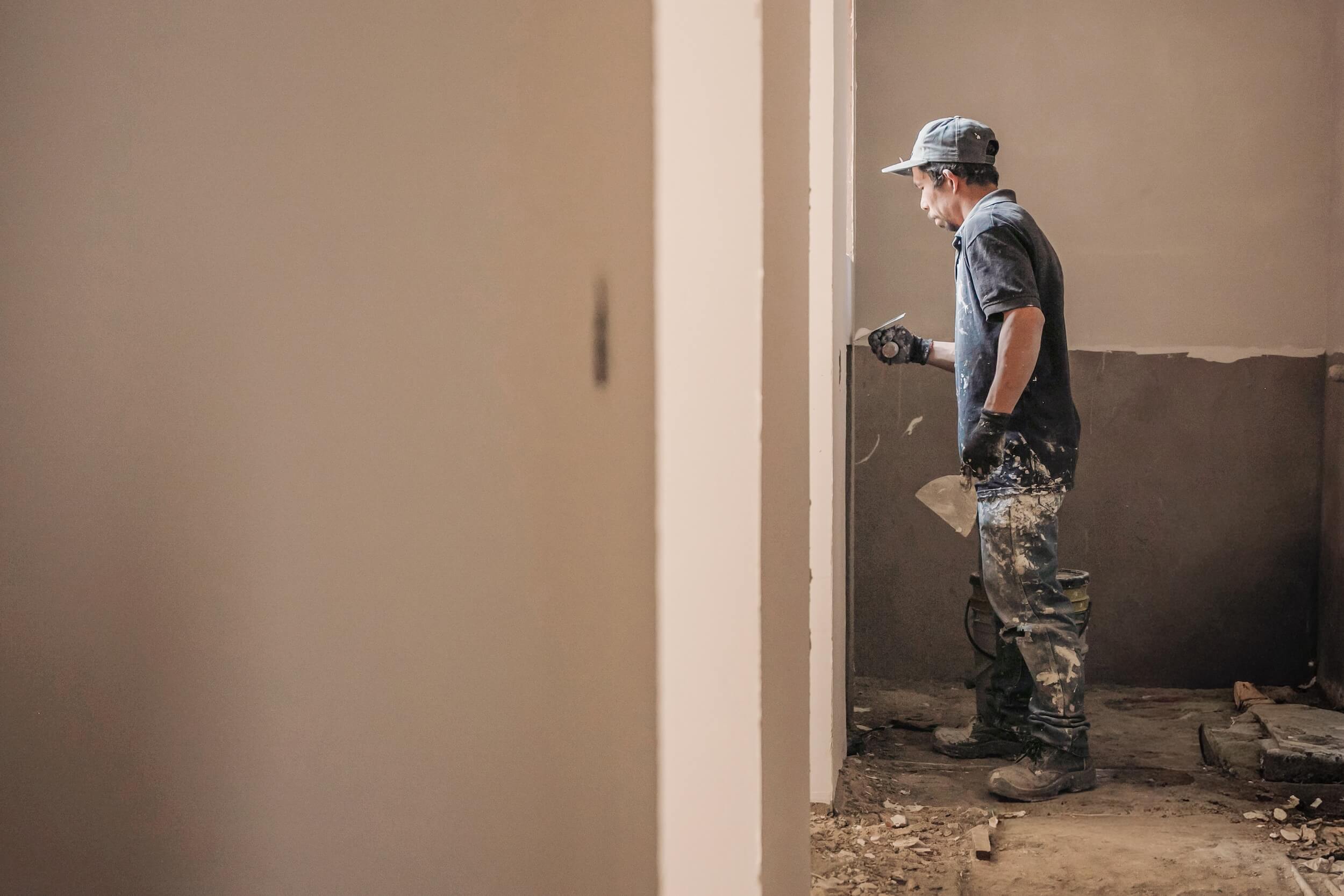 A plasterer bringing a wall to finish