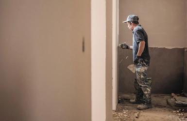 A plasterer bringing a wall to finish