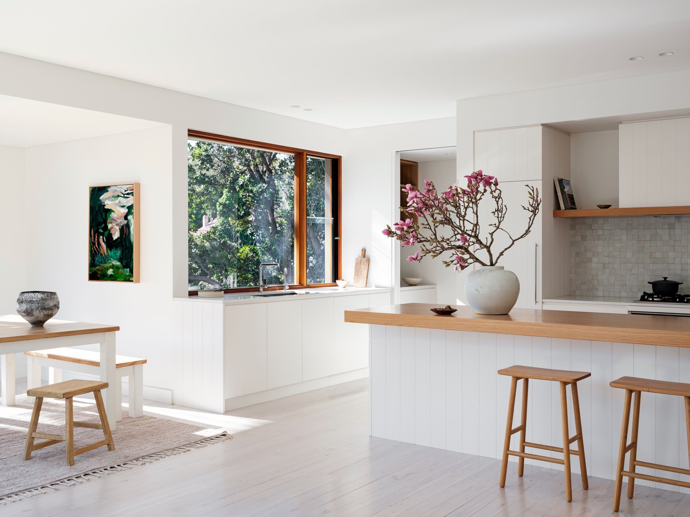 The dining table and benches beside the open corner window