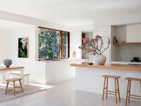 The dining table and benches beside the open corner window