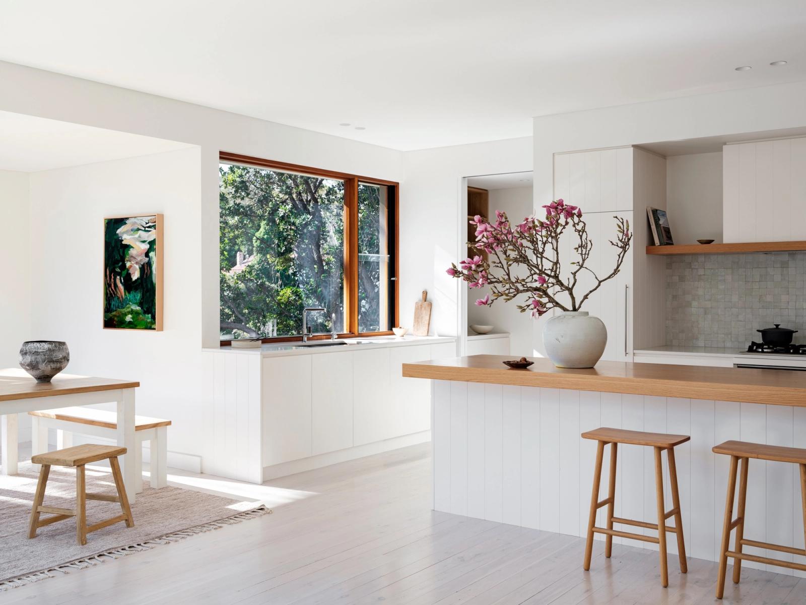The dining table and benches beside the open corner window