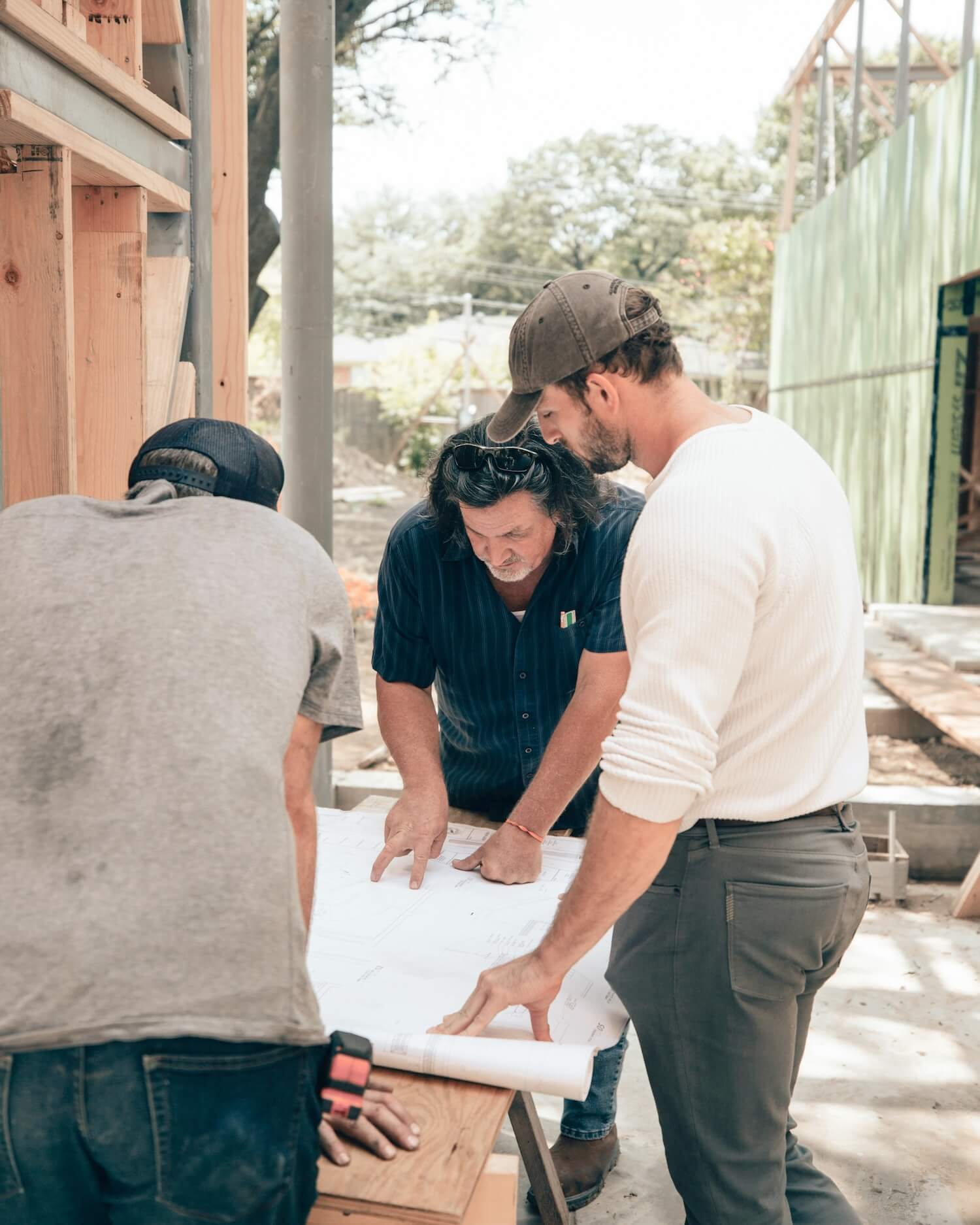 Builders reviewing plans together on site