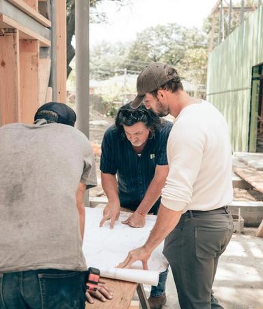 Builders reviewing plans together on site