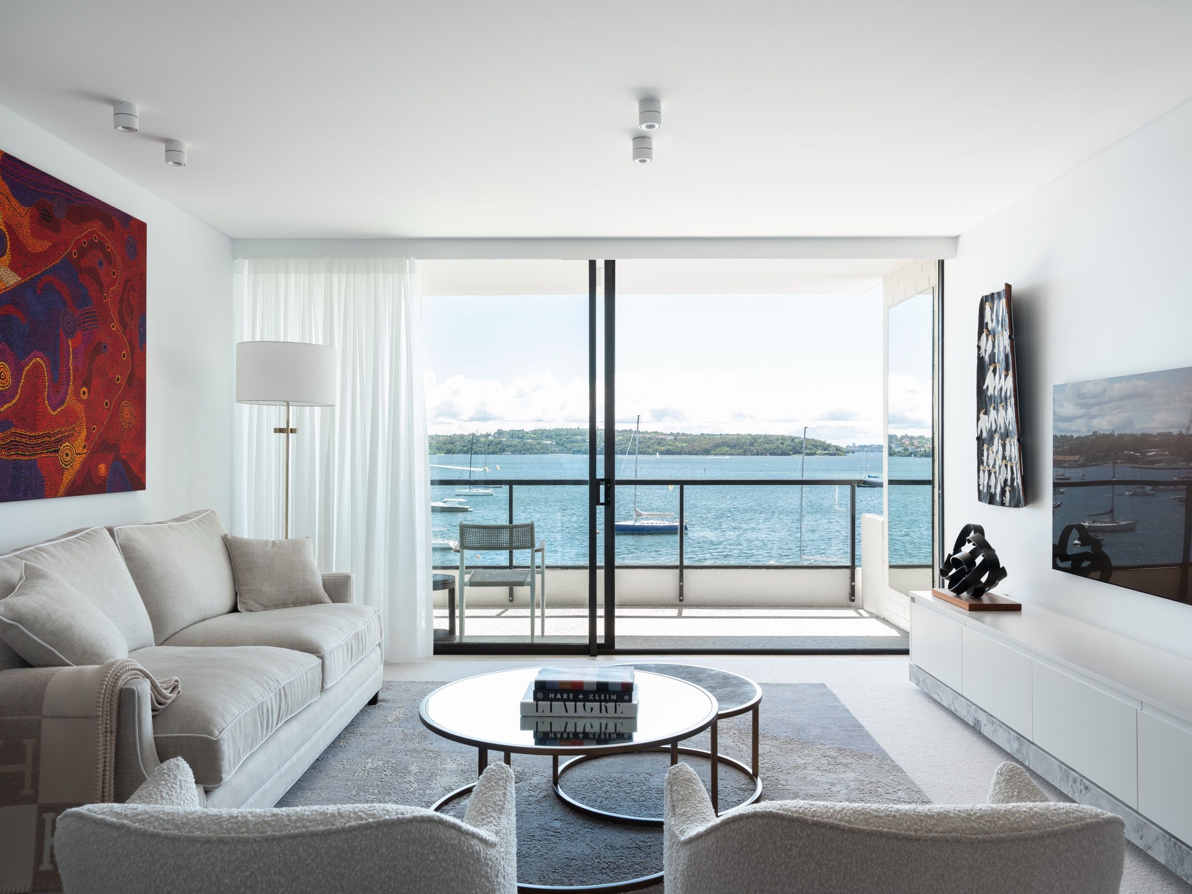 The living room opening to the balcony and Sydney Harbour beyond