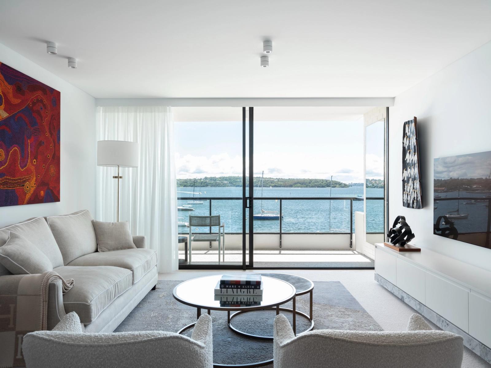 The living room opening to the balcony and Sydney Harbour beyond