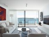 The living room opening to the balcony and Sydney Harbour beyond