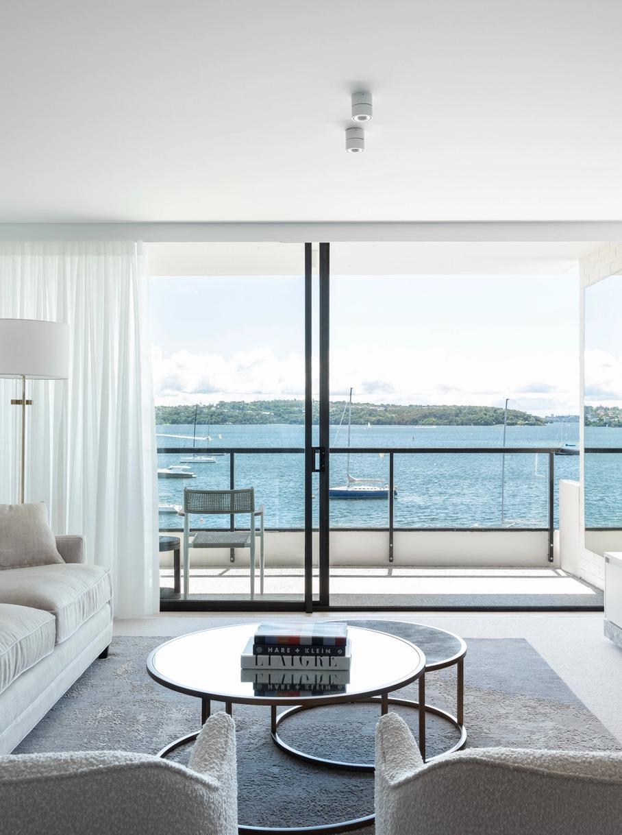 The living room opening to the balcony and Sydney Harbour beyond