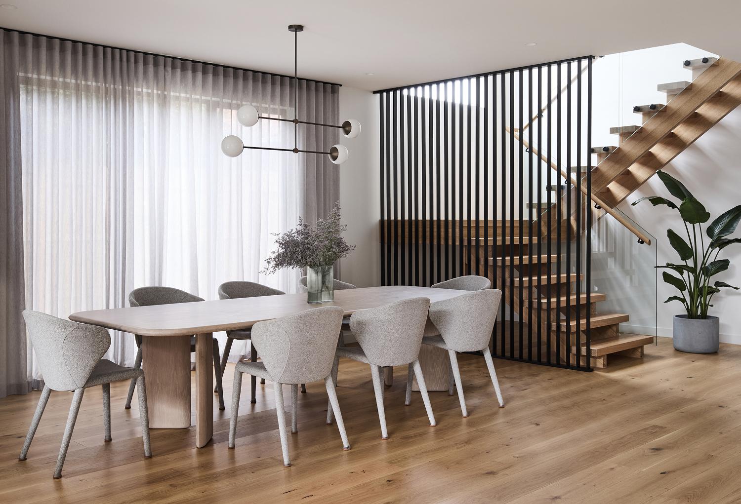 Open-plan contemporary dining and stairwell featuring, statement timber flooring, designed and built by Thomas Archer.