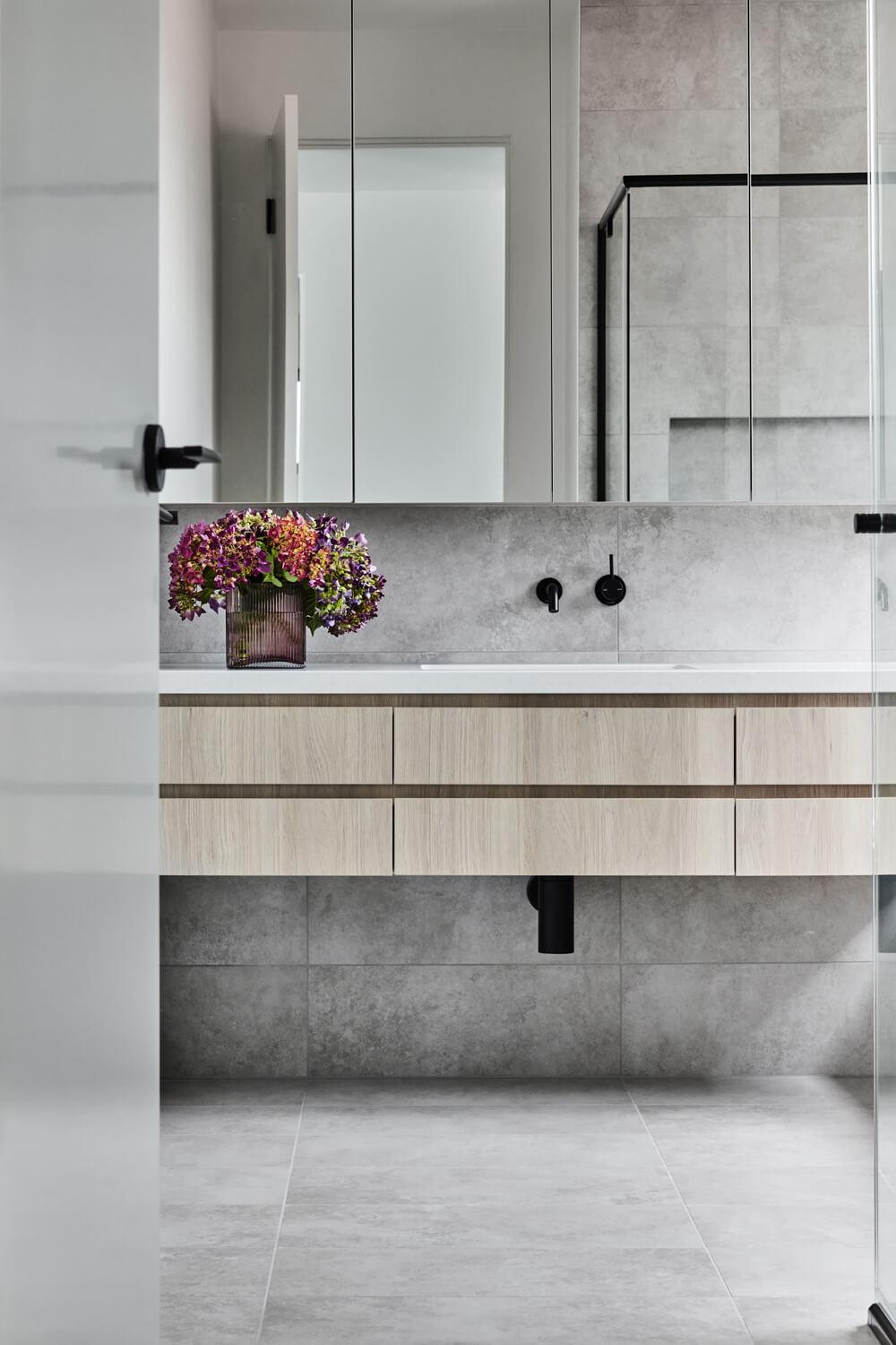 Modern Ensuite With Warm Cabinetry And Grey Tiling