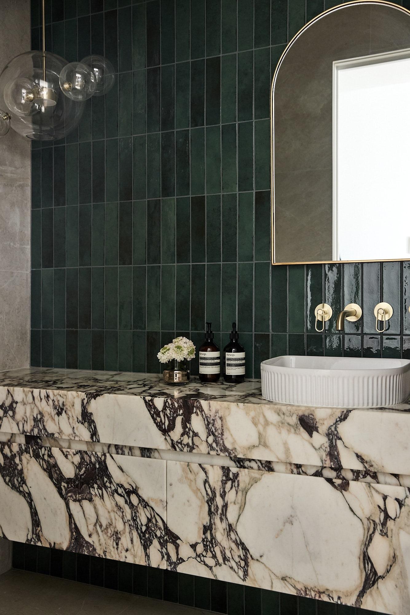 Thomas Archer designed powder room with feature green mosaic tiles and calacatta viola vanity