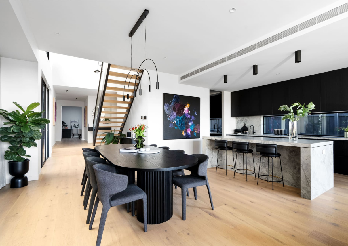 A contemporary open kitchen and dining space with timber flooring