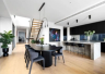 A contemporary open kitchen and dining space with timber flooring